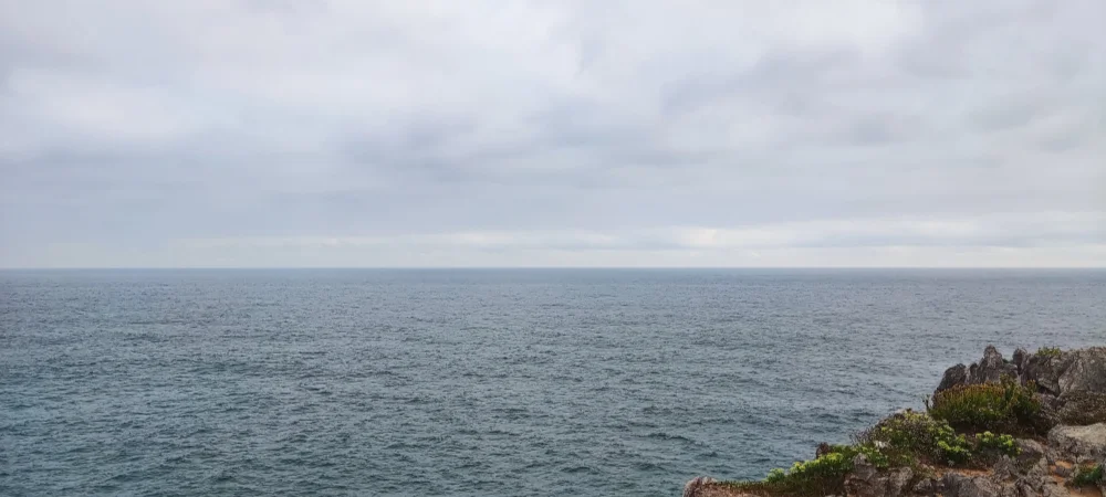 Fotografía con vistas a la costa del norte de España, centrada en el horizonte donde se juntan el mar y el cielo.